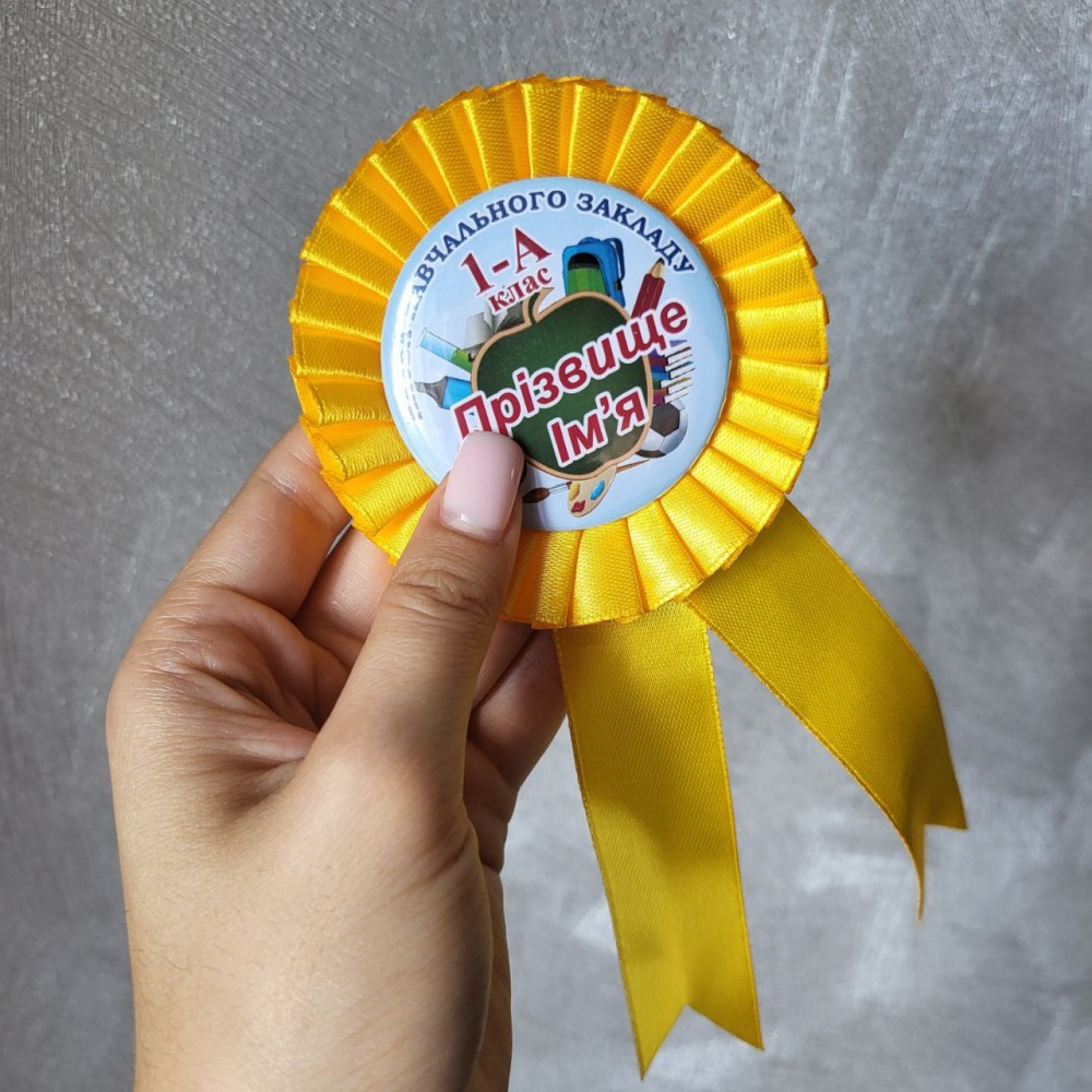 Значки першокласників з жовтою розеткою, стрічками Значки першокласників з жовтою розеткою, стрічками